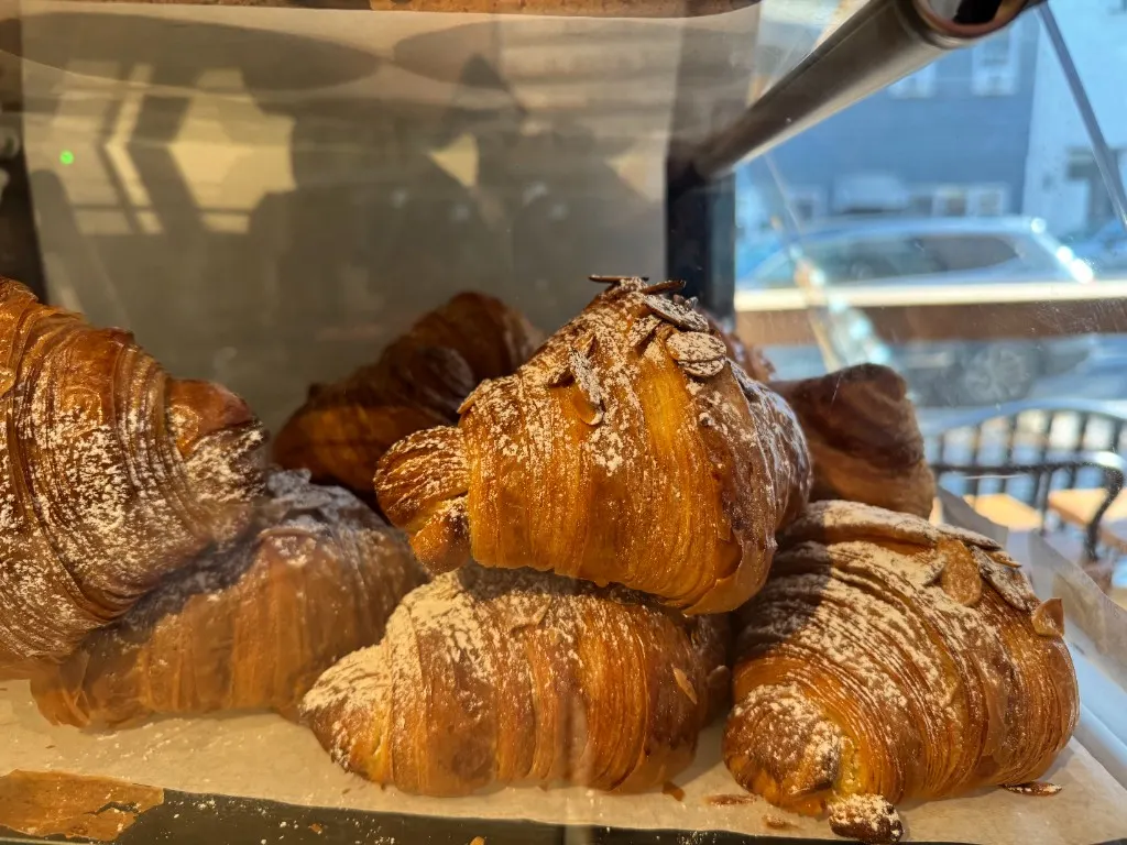 Almond croissants dusted with sugar in the pastry case